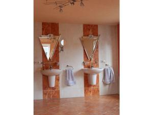 a bathroom with two sinks and two mirrors at Farsighted modern retreat in Annaberg-Buchholz