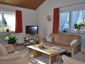 a living room with a couch and a tv at Haus Jörg Sosna Modern retreat in Bad Bayersoien