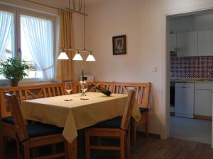 uma mesa de jantar com uma toalha de mesa amarela e copos de vinho em Haus Jörg Sosna Modern retreat em Bayersoien