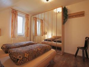 1 dormitorio con 2 camas y espejo en Lake View Modern Retreat, en Kirchdorf