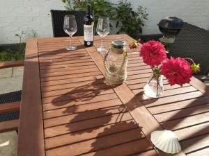 un tavolo in legno con bicchieri da vino e fiori di Birklund Modern Retreat a Probsteierhagen