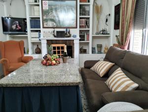 uma sala de estar com um sofá e uma mesa com fruta em CASA RURAL SITIO DE CASA NUEVA em La Guijarrosa