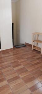 um quarto vazio com piso em madeira e uma mesa em The Hostal Elohim em Panajachel