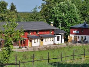 a couple of red and white buildings in a field at Ms Monika Rasehorn in Rehefeld-Zaunhaus