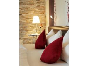 two red pillows sitting on a bed with a lamp at Kiesenberg 9 Modern retreat in Thanstein
