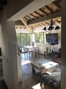 un salon avec une table et une télévision dans l'établissement Chambre d'Hôte vue exepitonnelle, à Uzès