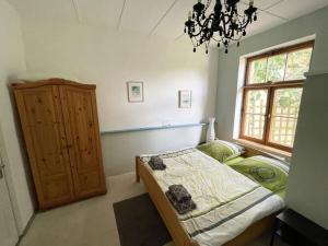 een slaapkamer met een bed, een raam en een kroonluchter bij Holiday home in Breetz üb Lenzen in Breetz