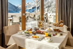 een tafel met ontbijtproducten en uitzicht op de bergen bij Hotel Tannenhof*****Superior in Sankt Anton am Arlberg