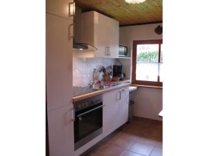 een keuken met witte apparatuur en een raam bij Strandfleh Modern retreat in Wangerooge