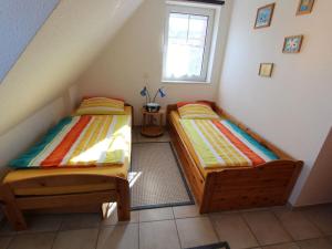 2 camas individuais num quarto com uma janela em Wattlöper left Modern retreat em Wittmund