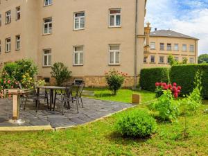 a patio with tables and chairs in front of a building at Holiday apartments Ender in Sebnitz