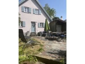 Casa con patio, mesa y sillas en Cozy Cottage Modern Retreat en Zankenhausen