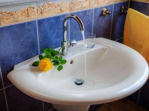 um lavatório com uma torneira com uma flor em Holiday apartments Ender em Sebnitz