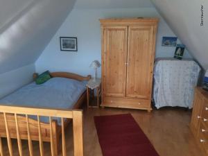 a bedroom with a bed and a wooden cabinet at Red-throated diver Modern retreat in Putgarten