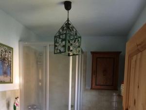 a chandelier hanging from a ceiling in a bathroom at Red-throated diver Modern retreat in Putgarten +12 photos