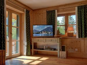 a living room with a flat screen tv and windows at Castle view Modern retreat in Oberhof