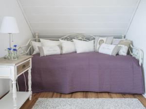 purpurowe łóżko z białymi poduszkami i stołem w obiekcie Elbwiesenhaus Modern retreat 