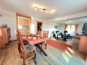 Il dispose d'une cuisine et d'un salon avec une table et des chaises en bois. dans l'établissement Haus Steiner Modern retreat, à Oberstdorf