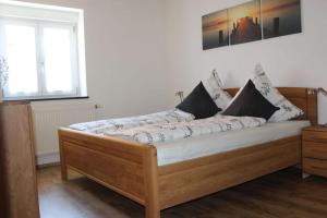 - un lit en bois dans une chambre avec fenêtre dans l'établissement Apartment in Hergensweiler, à Hergensweiler