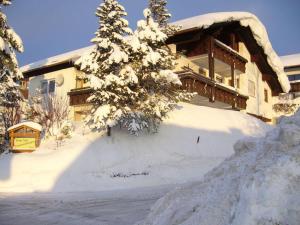 a house with a pile of snow in front of it at Haus Nett Modern retreat in Stiefenhofen