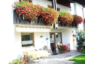 ein Gebäude mit einem Tisch, Stühlen und Blumen in der Unterkunft Haus Nett Modern retreat in Stiefenhofen