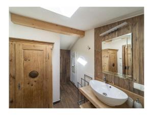 La salle de bains est pourvue d'un lavabo blanc et d'un miroir. dans l'établissement The Koflhittl Modern retreat, à Ciardes