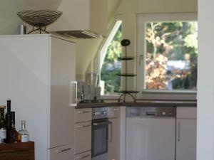 una cocina con electrodomésticos blancos y una ventana en Mountain Modern Retreat, en Trippstadt