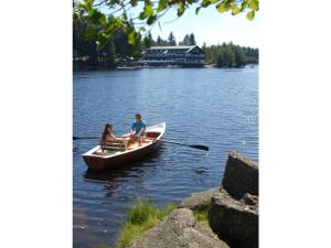 two people in a row boat on a lake at Köferl Modern retreat in Fichtelberg