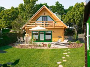 uma casa com um cão sentado no quintal em F Winkler Modern retreat em Neukalen