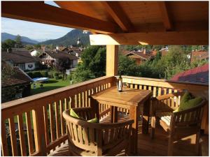 a wooden table and chairs on a wooden deck at Villa Carefree Suite in Grassau