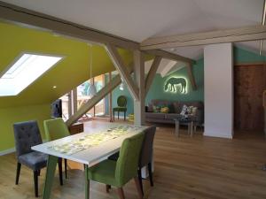 a dining room with a table and green chairs at Villa Carefree Suite in Grassau