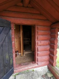 una entrada a una cabaña de madera con puerta en Torpet, en Sollebrunn