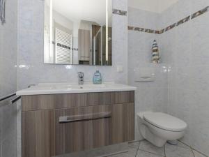 een badkamer met een wastafel, een toilet en een spiegel bij 2 Am Stadtwald Modern retreat in Kühlungsborn +12 foto's