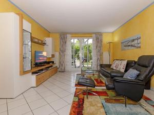 een woonkamer met een bank en een tv bij 2 Am Stadtwald Modern retreat in Kühlungsborn