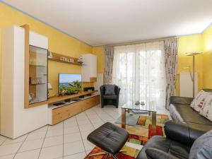 een woonkamer met een bank en een televisie bij 2 Am Stadtwald Modern retreat in Kühlungsborn