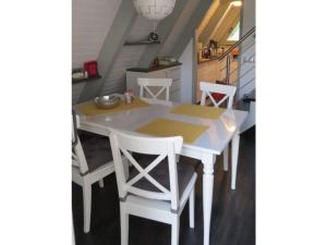 a dining room table with white chairs and a kitchen at Sunshine Modern Retreat in Ronshausen