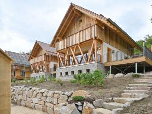 una gran casa de madera con una pared de piedra en Grandma Ludwin 1 Modern retreat en Sasbachwalden