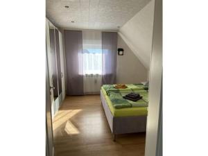 ein kleines Schlafzimmer mit einem Bett in einem Zimmer in der Unterkunft Holiday apartment Burg-Hohenstein in Burg Hohenstein