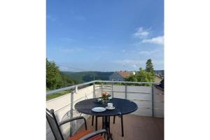 einen Balkon mit einem Tisch und Stühlen auf einer Terrasse in der Unterkunft Holiday apartment Burg-Hohenstein in Burg Hohenstein