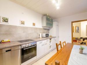 cocina con electrodomésticos blancos y mesa de madera en Holiday apartment Alstaden 1, en Oberhausen