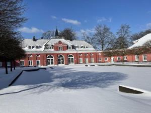 un grand bâtiment en briques rouges avec de la neige au sol dans l'établissement Holiday apartment Alstaden 1, à Oberhausen