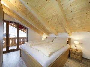 a large white bed in a room with wooden ceilings at Partnachklamm Modern retreat in Garmisch-Partenkirchen