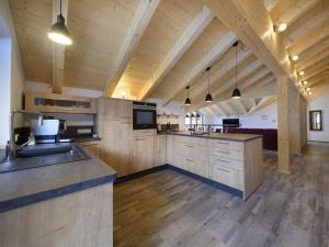 a large kitchen with wooden cabinets and a counter top at Partnachklamm Comfortable holiday residence in Garmisch-Partenkirchen +13 photos