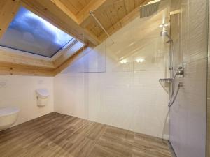 a bathroom with a shower and a toilet and a skylight at Partnachklamm Modern retreat in Garmisch-Partenkirchen
