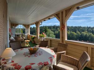 a screened in porch with a table and chairs at Landhuis Appartement Feldberg uitzicht in Sankt Märgen