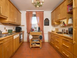 a large kitchen with wooden cabinets and a window at Landhuis Appartement Feldberg uitzicht in Sankt Märgen