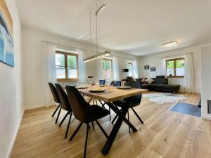 a dining room and living room with a table and chairs at Oberland Stadlberg in Miesbach