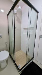 La salle de bains est pourvue d'une douche en verre et de toilettes. dans l'établissement Residencial do Centro, à Niterói