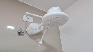 a white hair dryer sitting on the floor in a bathroom at Residencial do Centro in Niterói