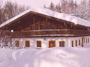 una gran casa de madera con nieve en el techo en Holiday guesthouse Posthof, en Waldmünchen